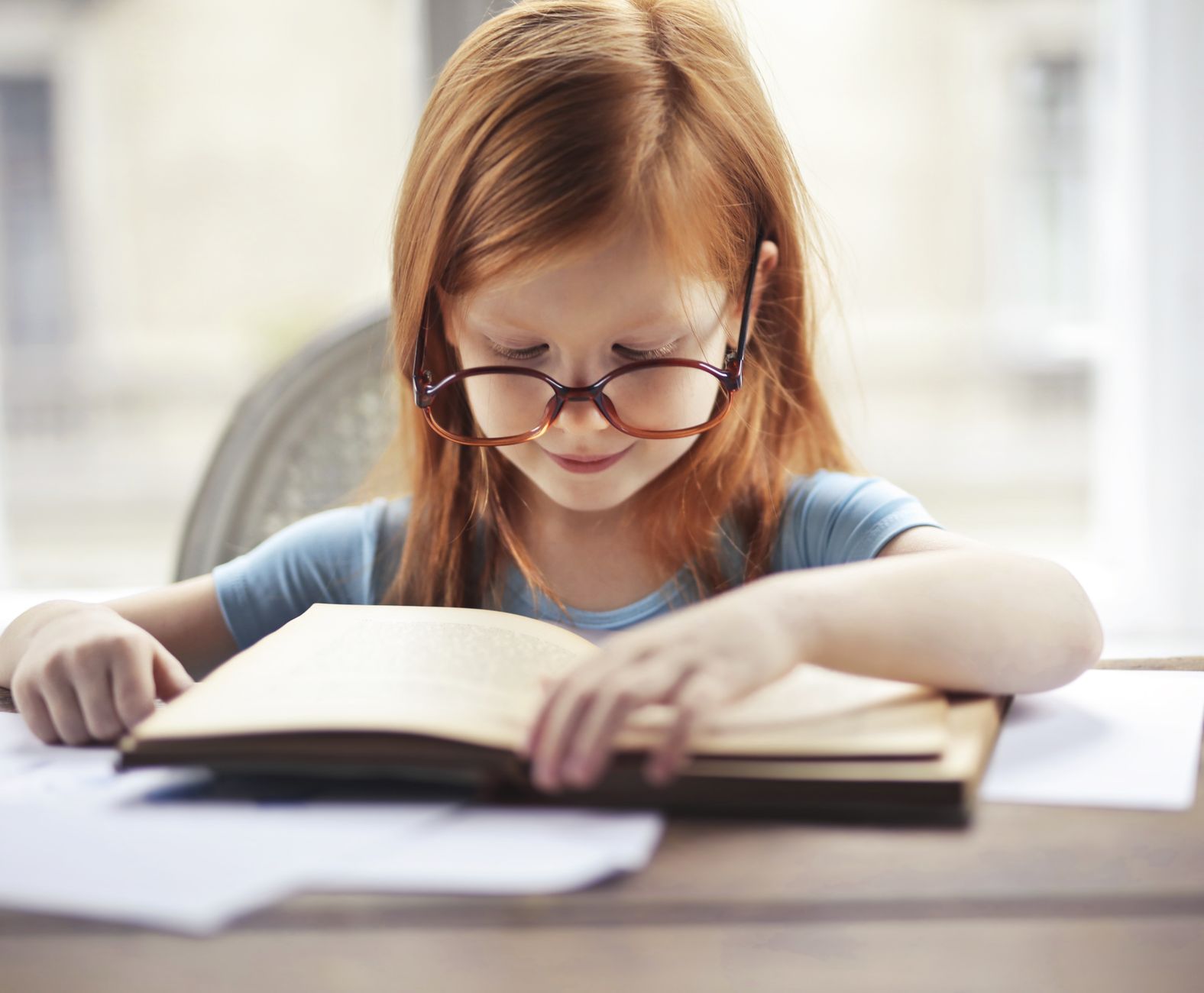 Girl in glasses reading a classic book
