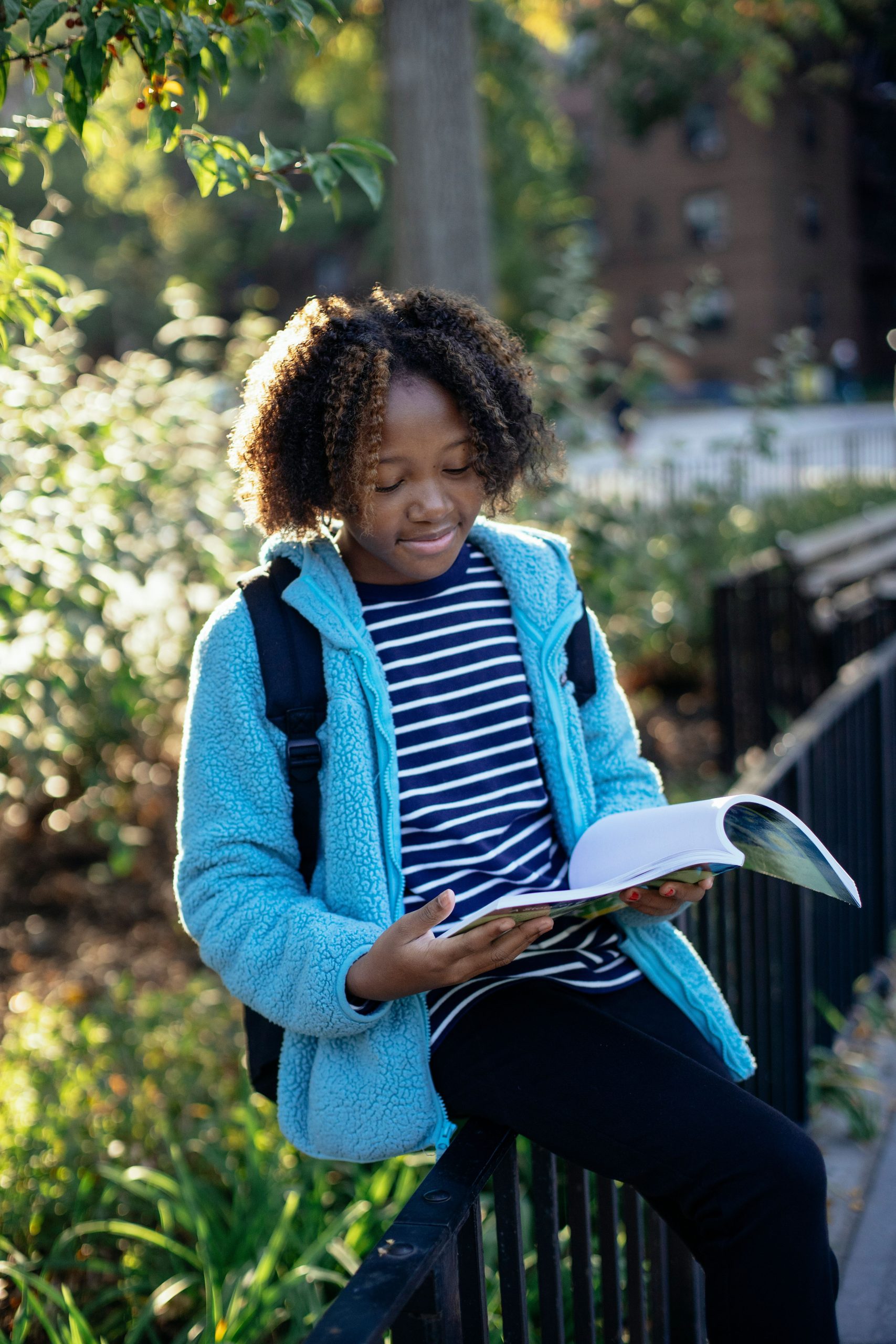 young girl reading a book outside